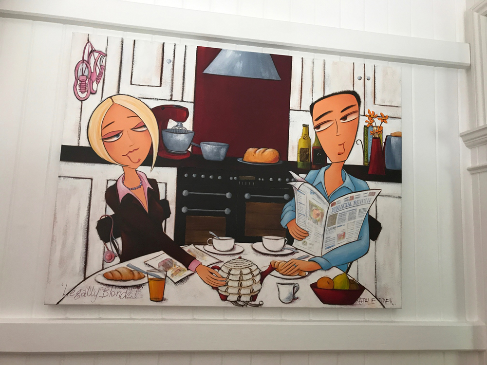 Legally Blonde hanging high on a white panelled wall in Simon and Meredith's home, the kitchen portrait in the kitchen it was painted for